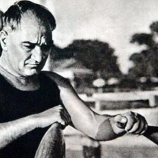 Vintage Black and White Photograph of a Man Exercising with Indian Clubs